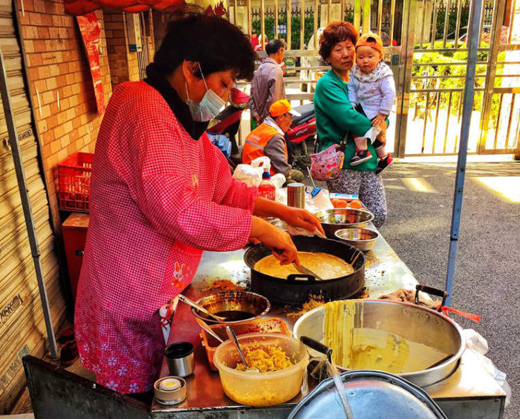的是最正宗的老式上海鸡蛋饼,店主是一对老夫妻,穿红色围裙的阿姨姓张