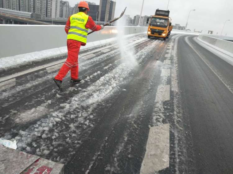 申城市政员工撒盐除积雪,确保雪后道路依然畅通