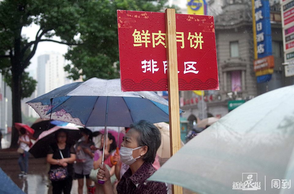 50 新雅食品门外用绳子拉了个鲜肉月饼排队区,市民有序地排着队.